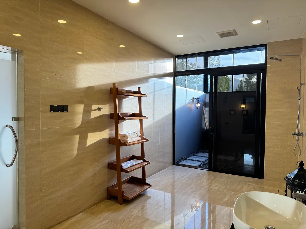 Inside a deluxe bathroom: a timber towel rack and the door through to the outdoor shower