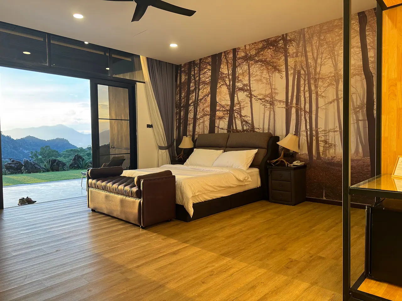 The second deluxe king room, with glass doors open to the lawn and the mountains