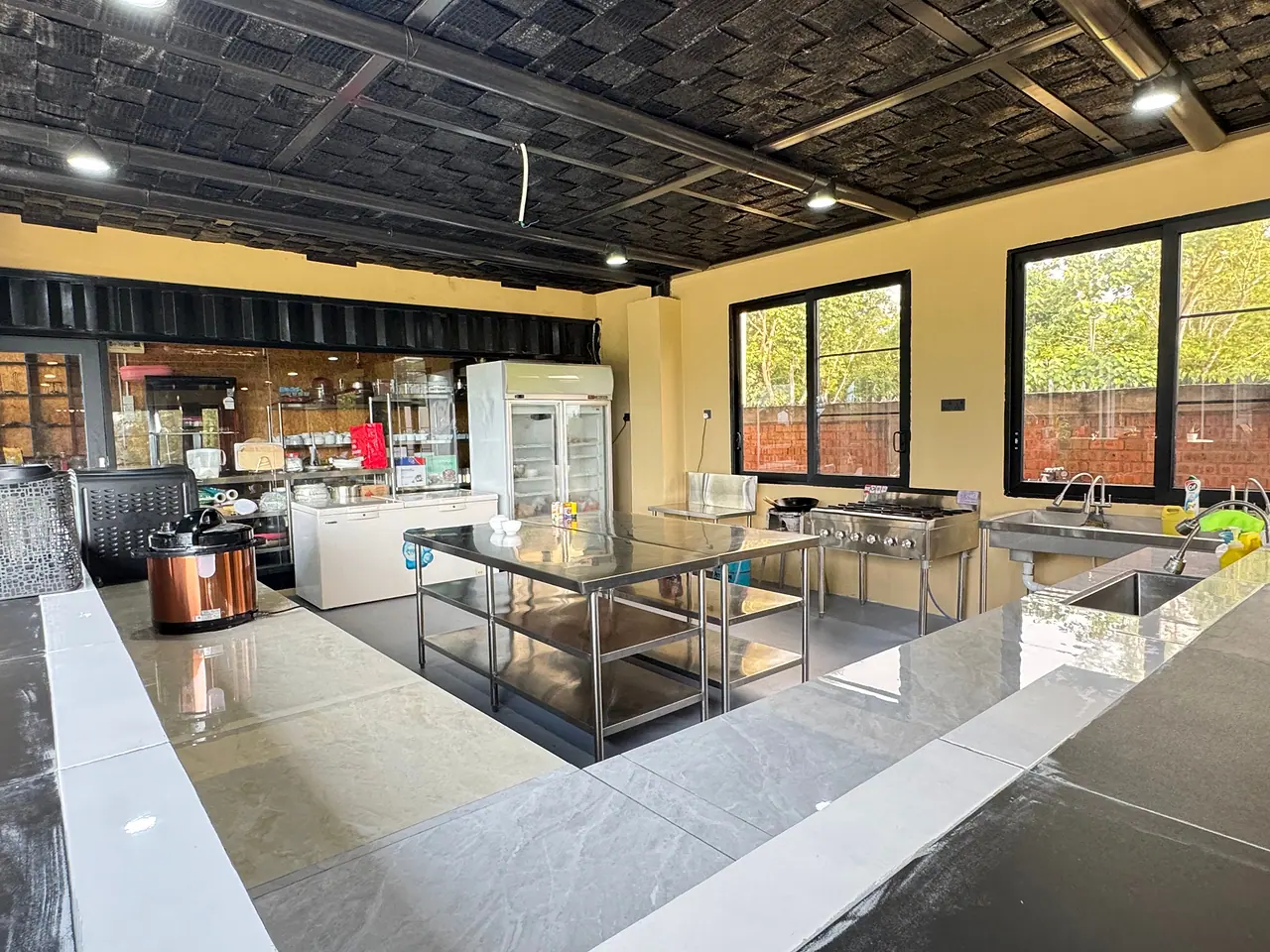 The estate kitchen: stainless steel prep tables, cookers and a glass-door fridge
