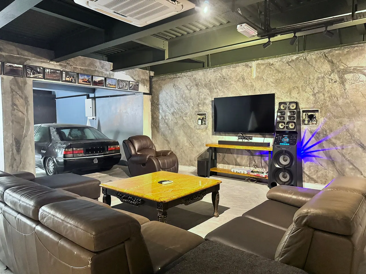 The basement lounge, with a classic car parked alongside the sofas and the karaoke system
