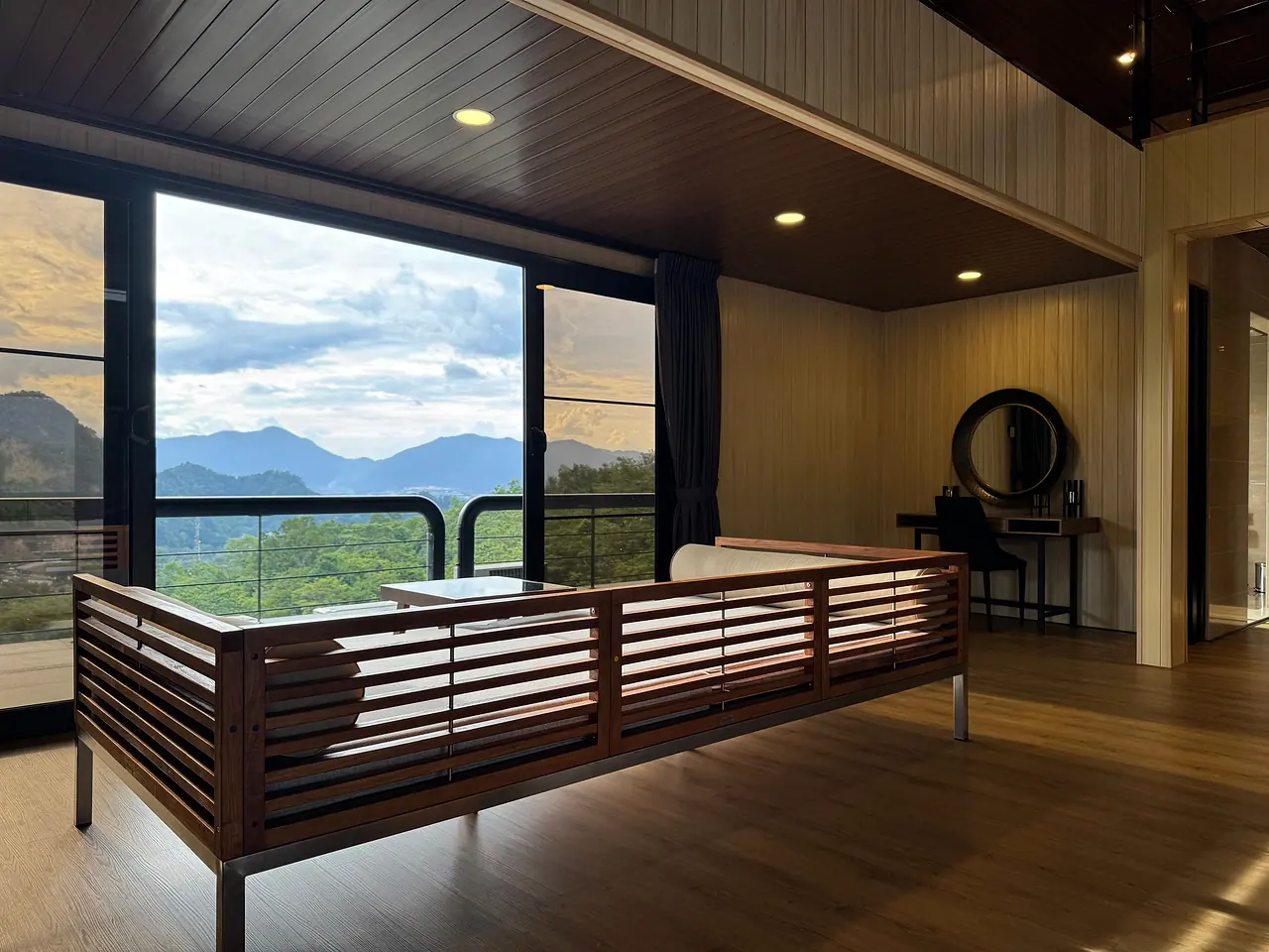 A slatted timber sofa facing the penthouse windows and the limestone hills