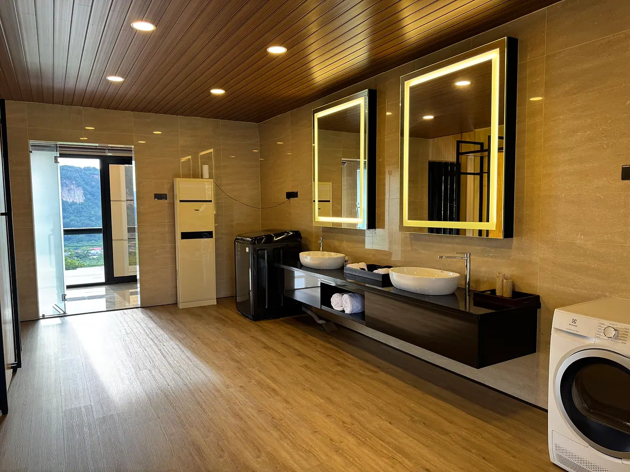 His-and-hers basins under lit mirrors in a penthouse bathroom