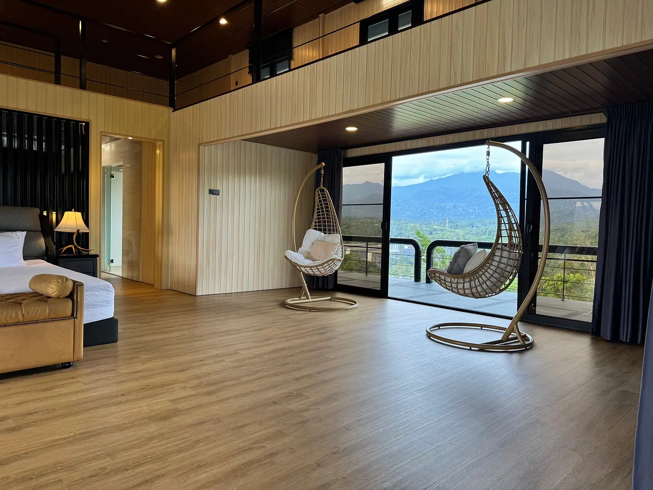 The penthouse sitting area: hanging chairs by glass doors to the balcony and the hills