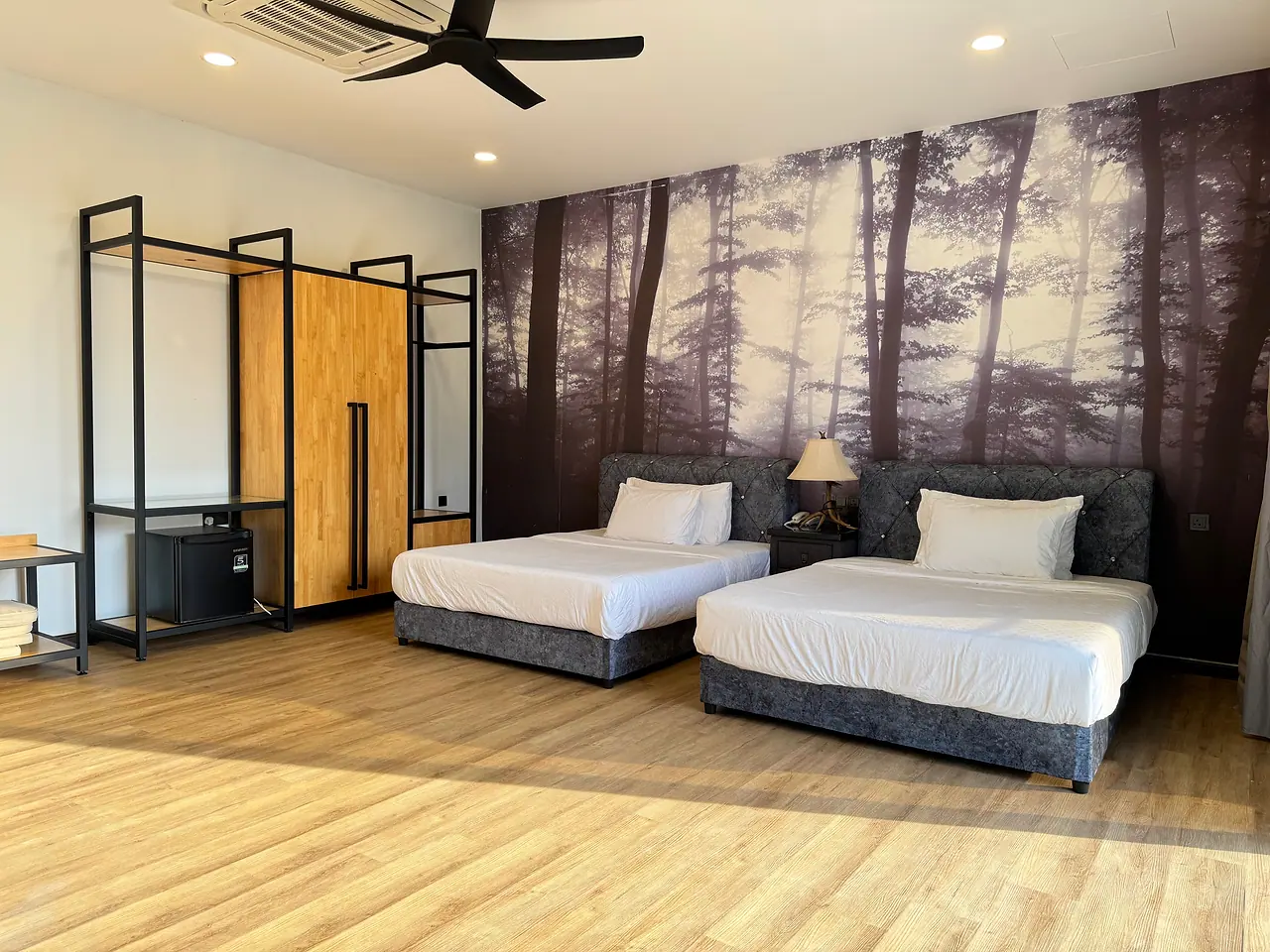 The deluxe room with two queen beds, a forest mural and an open wardrobe