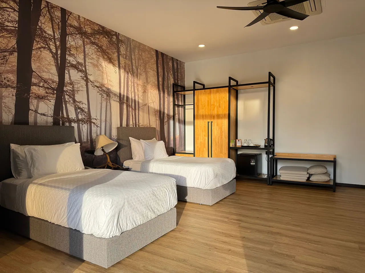 The deluxe twin room: two single beds against a misty forest mural