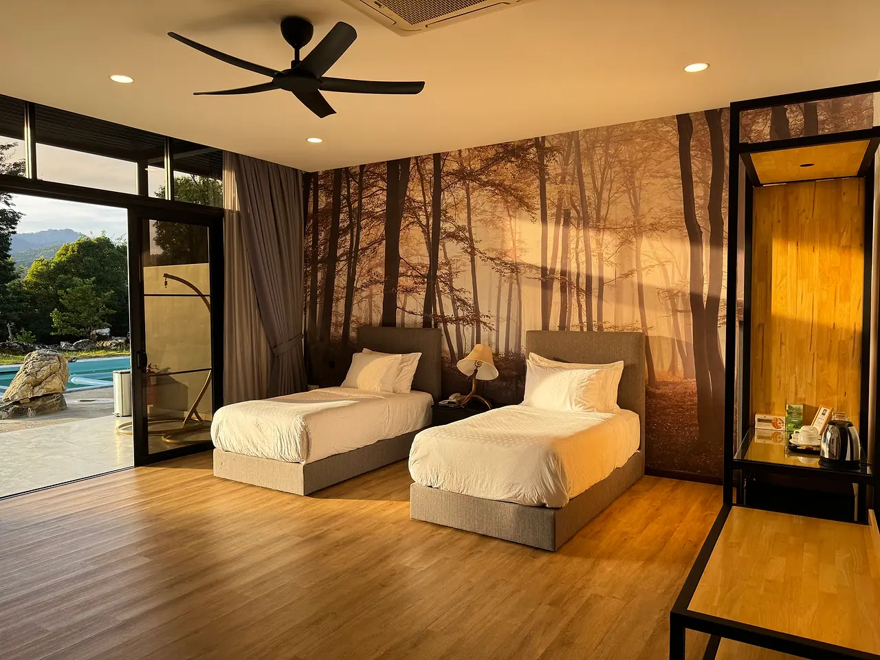 The two single beds in the twin room, with glass doors and the pool just outside